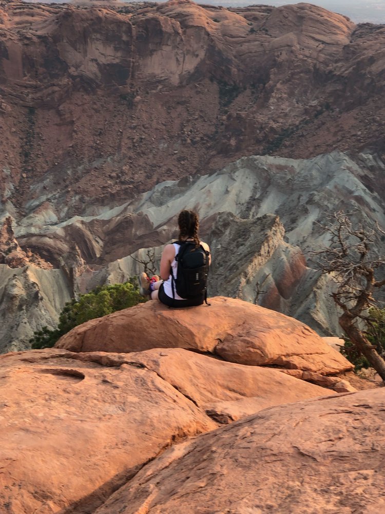 woman looking out over crater in arches national park in utah, usa; mother daughter trip; road trip south west; south west usa; utah travel itinerary; road trip tips; female travel; united states national park trip