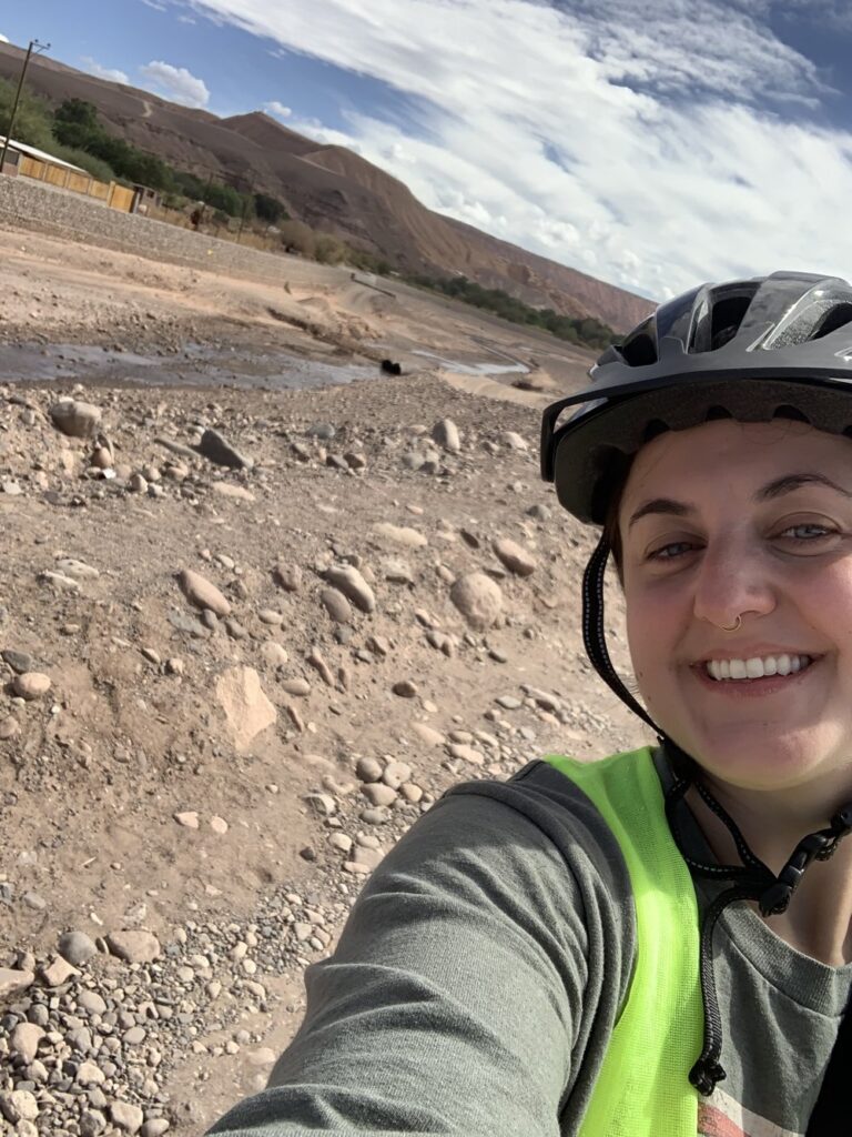 woman bike riding in san pedro de atacama chile; south american desert; solo travel; solo female travel; backpacking south america; backpacking tips; chile travel itinerary; chile travel; south america travel destinations; where to visit in south america