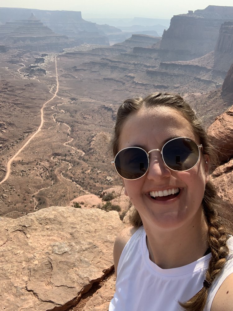 woman smiling in canyonlands national park in utah, usa; mother daughter trip; road trip south west; south west usa; utah travel itinerary; road trip tips; female travel; united states national park trip