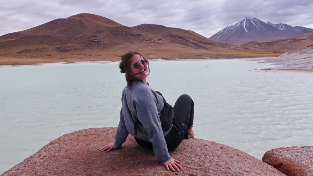 woman on rock in the Piedras Rojas section of the San Pedro de Atacama desert; san pedro de atacama chile; south american desert; solo travel; solo female travel; backpacking south america; backpacking tips; chile travel itinerary; chile travel; south america travel destinations; where to visit in south america