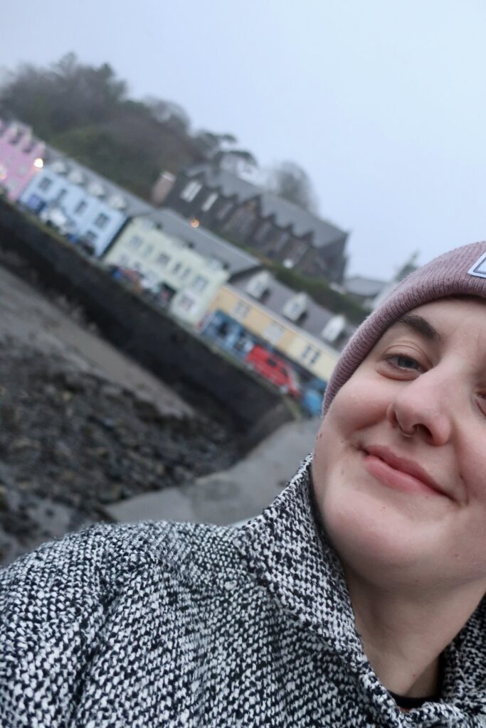 woman in portree harbour scotland, united kingdom, europe; harry potter movies; solo travel; solo female travel; roadtrip scotland; roadtrip europe; scotland itinerary