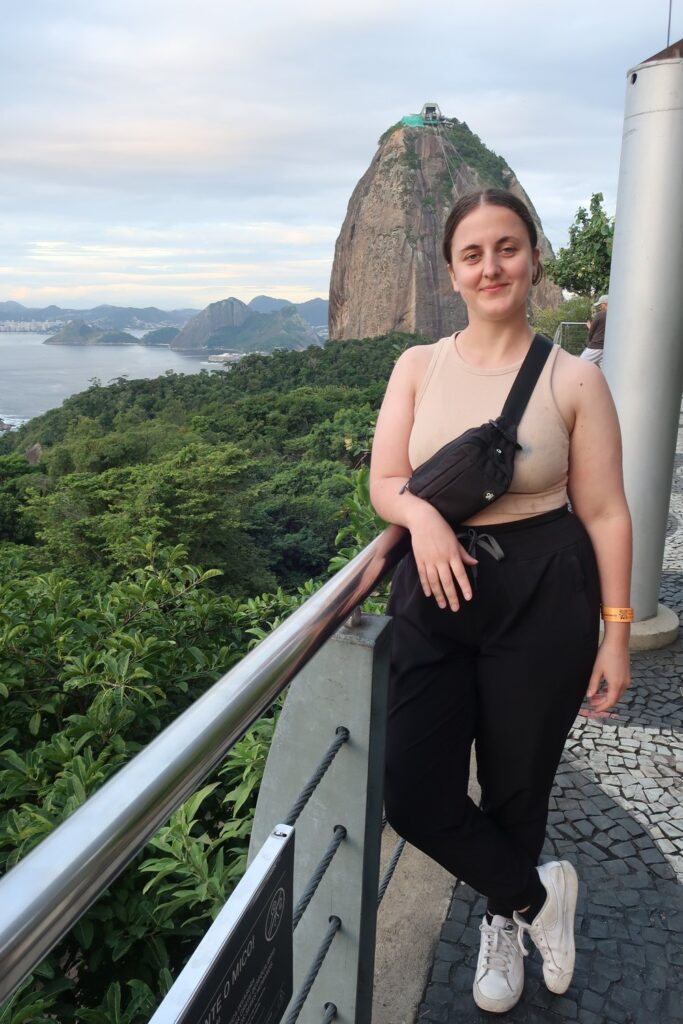 woman standing on balcony on sugarloaf in urca neighborhood in Rio de Janeiro, Brazil; backpacking south america; solo backpacking trip; female backpacking trip tips; solo travel tips; solo female travel; brazil travel itinerary