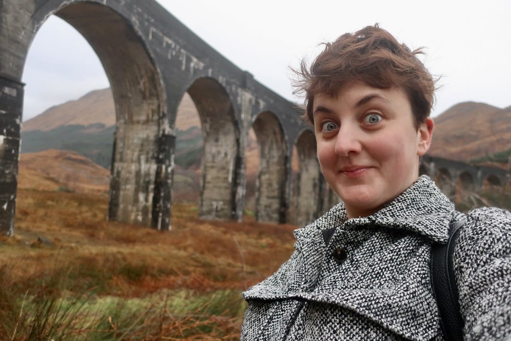 woman at glenfinnan viaduct in scotland, united kingdom, europe; harry potter movies; solo travel; solo female travel; roadtrip scotland; roadtrip europe; scotland itinerary