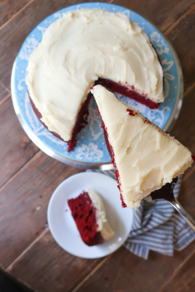 red velvet cake with cream cheese frosting on blue floral plate