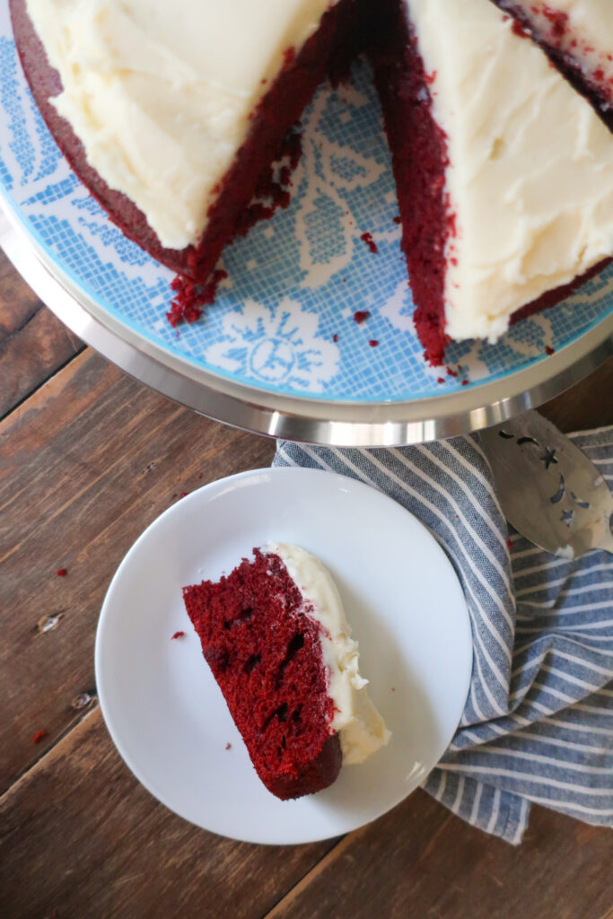 red velvet cake with cream cheese frosting on blue floral plate