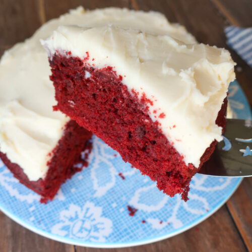 red velvet cake with cream cheese frosting on blue floral plate