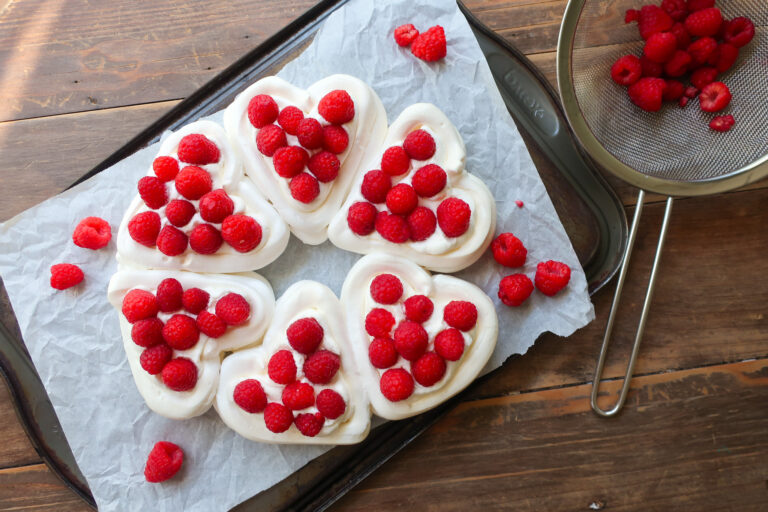 pavlova hearts wreath with french meringue, piped into heart baskets and filled with fresh whipped cream and fresh raspberries