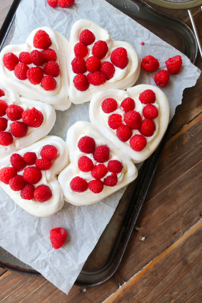 pavlova hearts wreath with french meringue, piped into heart baskets and filled with fresh whipped cream and fresh raspberries