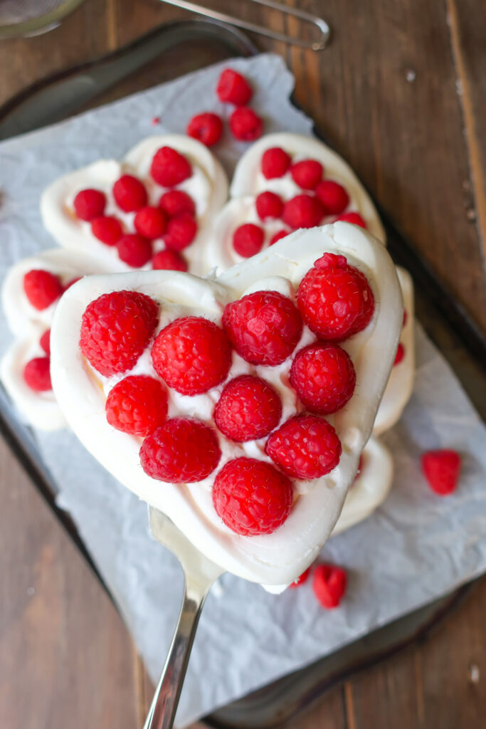 pavlova hearts wreath with french meringue, piped into heart baskets and filled with fresh whipped cream and fresh raspberries