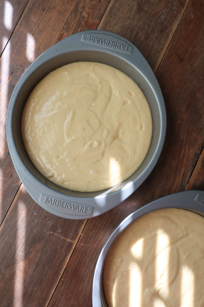 yellow cake batter in round cake pans, yellow tiered cake with chocolate buttercream frosting