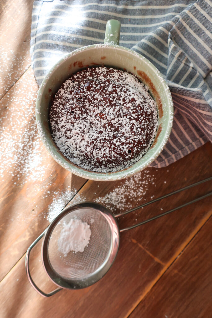 moist chocolate mug cake dusted with powdered sugar