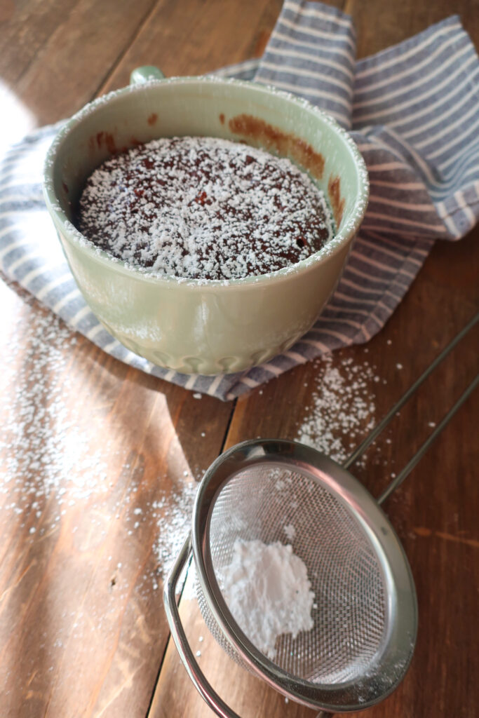 moist chocolate mug cake dusted with powdered sugar