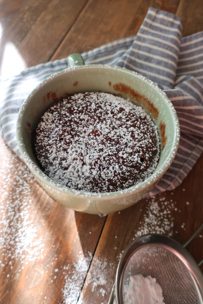 moist chocolate mug cake dusted with powdered sugar