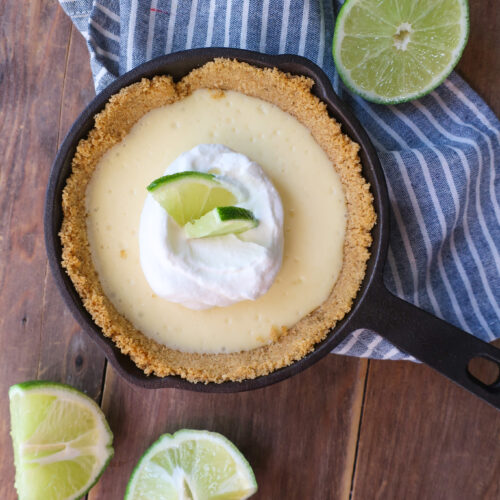 mini single-serve key lime cheesecake with whipped cream topping in mini cast iron skillet, individual cheesecake