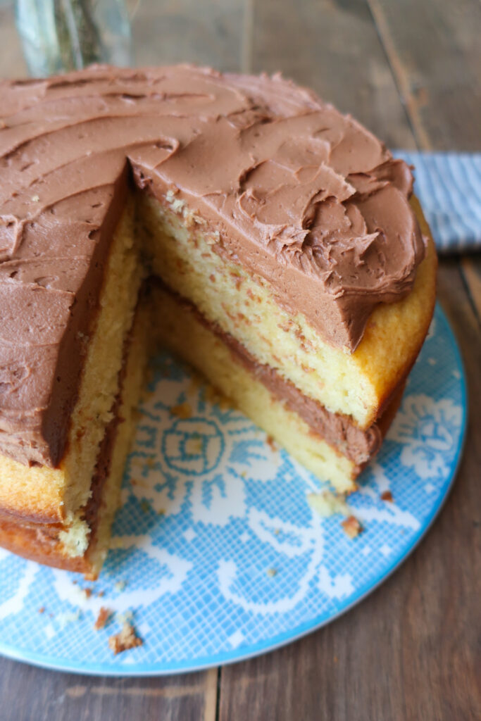 yellow tiered cake with chocolate buttercream frosting