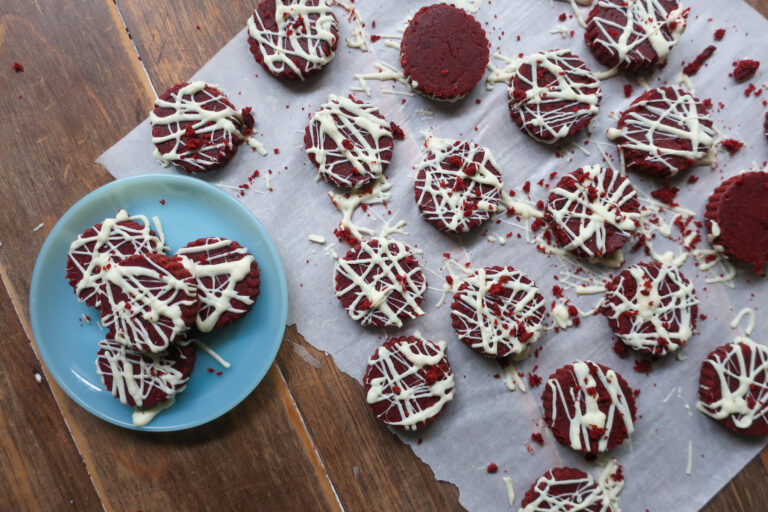 flat circle shapes of red velvet cake pops with white chocolate drizzle with no popsicle or lollipop stick