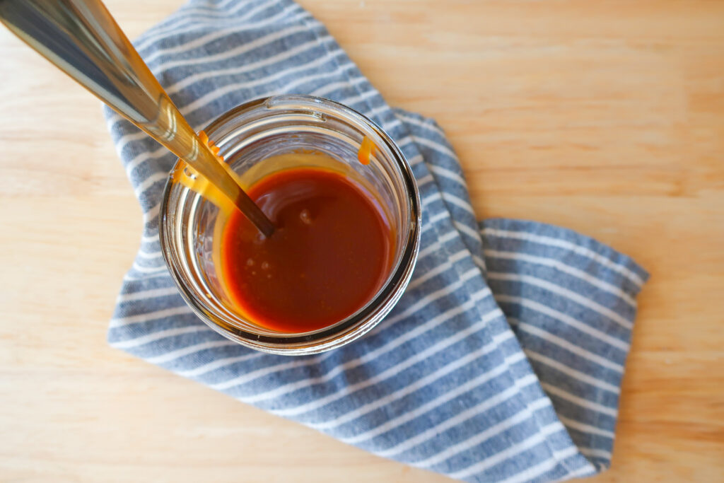 mason jar filled with homemade 10 minute salted caramel sitting on striped blue and white napkin