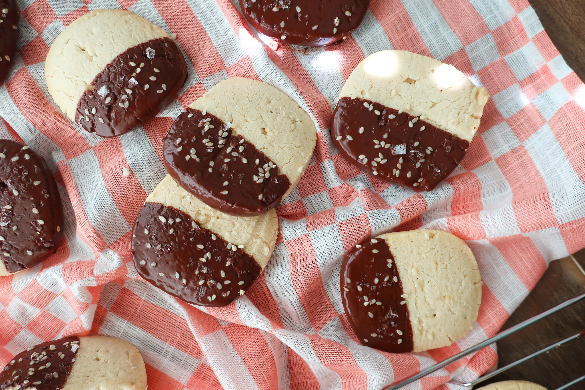 shortbread cookies dipped in chocolate, chocolate dipped cookies on pink and white cloth, easy bittersweet chocolate dipped sesame shortbread cookies