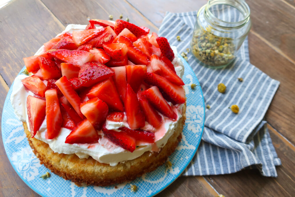 spring baking, spring desserts, fresh whipped cream, strawberry cake, strawberry shortcake, dried chamomile flowers in a glass jar, the best chamomile strawberry shortcake with chamomile cake two-ingredient whipped cream and macerated strawberries