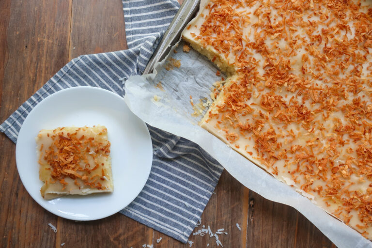 slice cake next to pan of coconut texas sheet cake