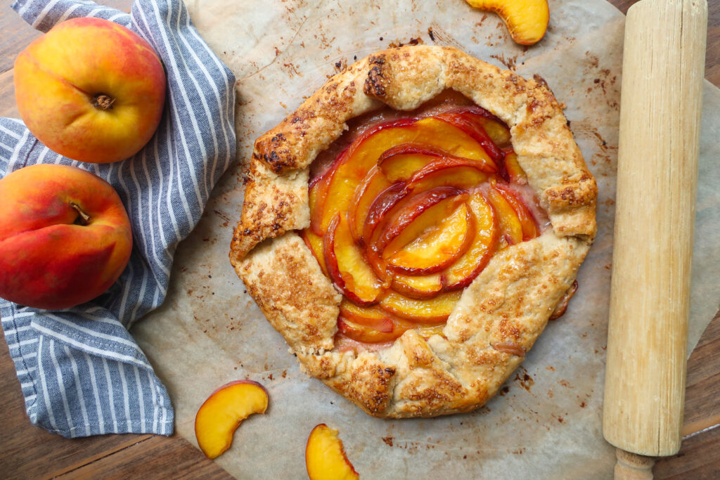 baked peach galette on parchment paper