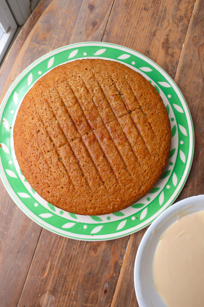 cinnamon olive oil cake next to bowl of glaze