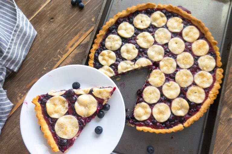 slice of blueberry tart next to whole tart