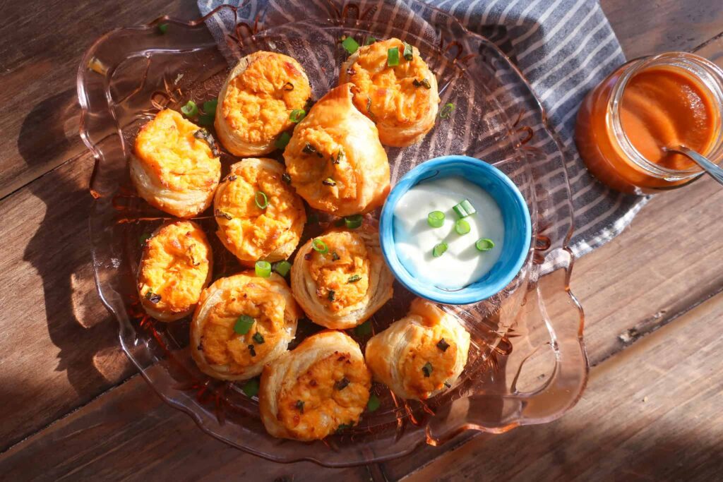 buffalo chicken puff pastry rolls on plate with blue cheese dressing