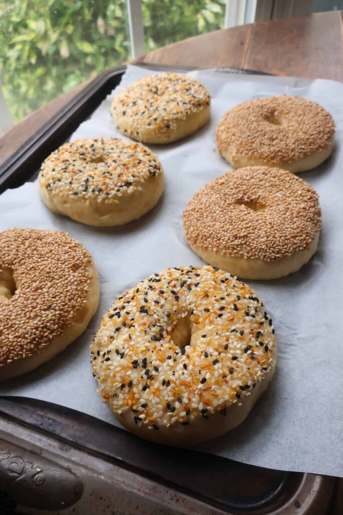 topped bagels on baking sheet ready to be baked