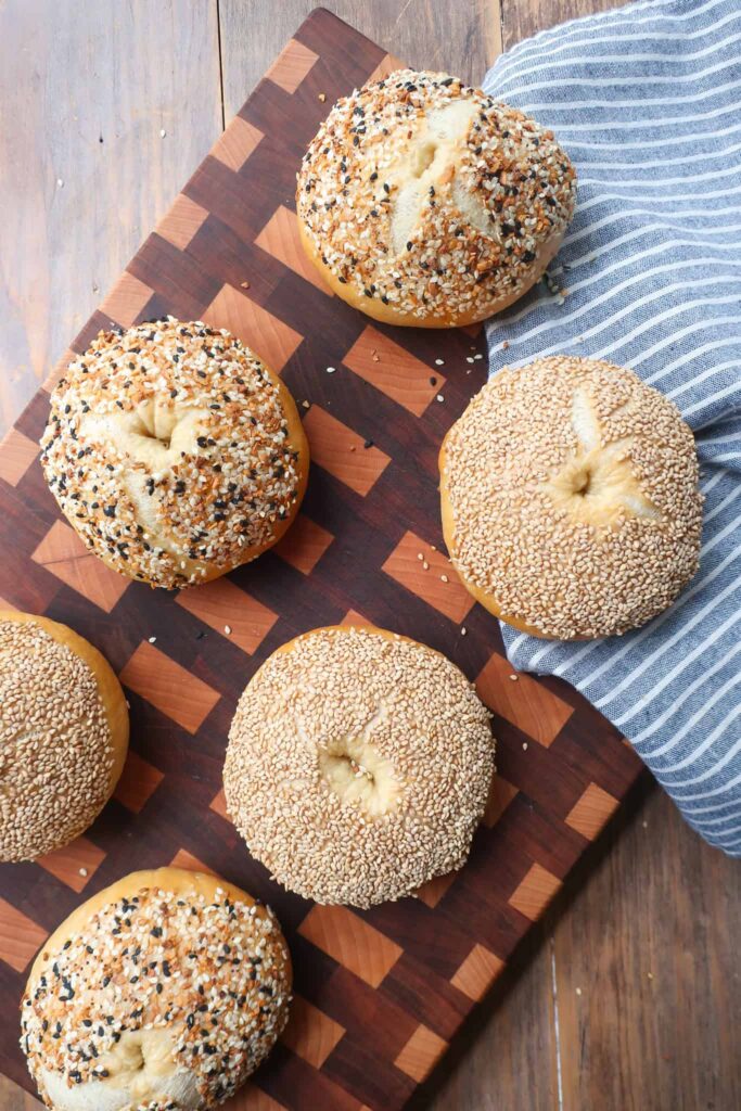 sesame and everything bagels baked on cutting board