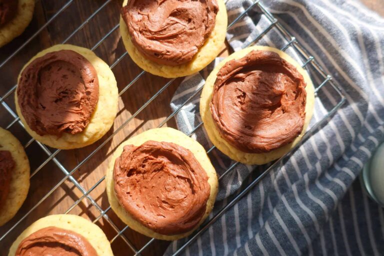 yellow cake cookies with chocolate buttercream on rack