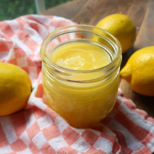 homemade lemon curd in jar in front of window
