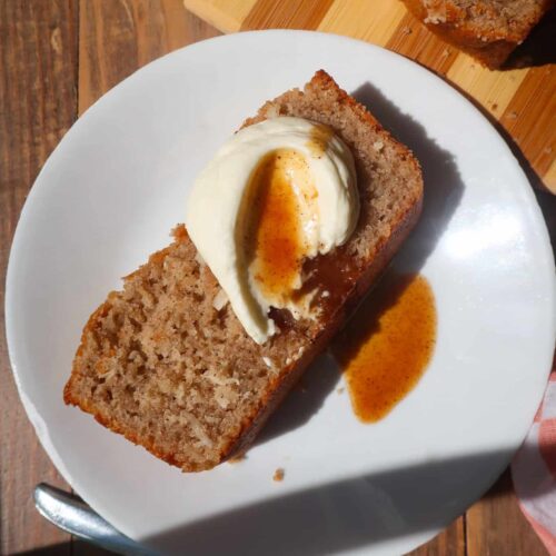 loaf cake slice topped with cream and carrot cake sauce
