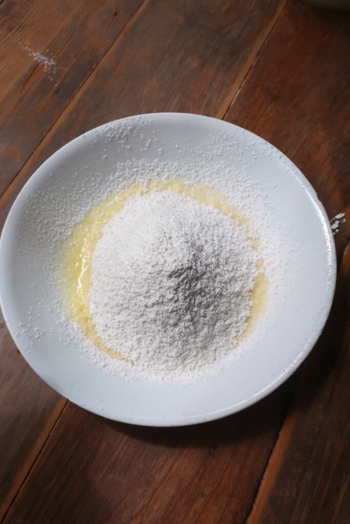 powdered sugar in white bowl with melted butter