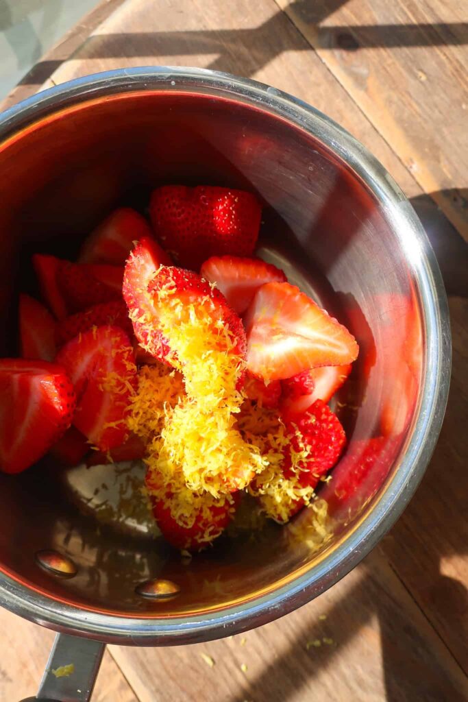 fresh strawberries and lemon zest in pot