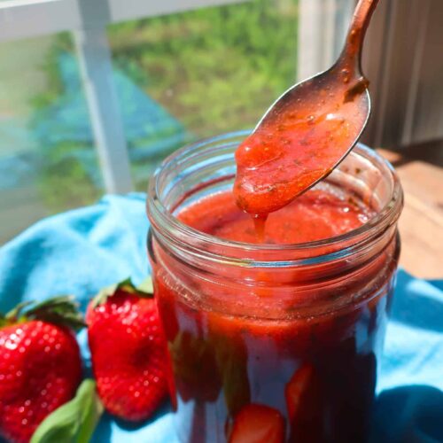 strawberry basil sauce in jar with spoon