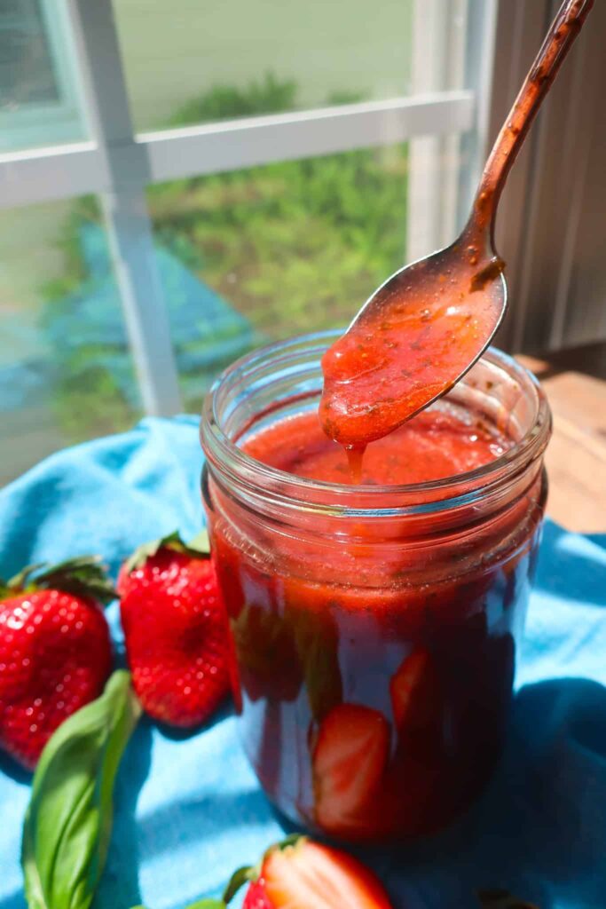 strawberry basil sauce in jar with spoon