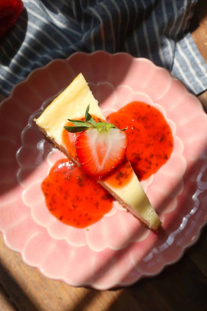 vanilla cheesecake slice topped with strawberry sauce