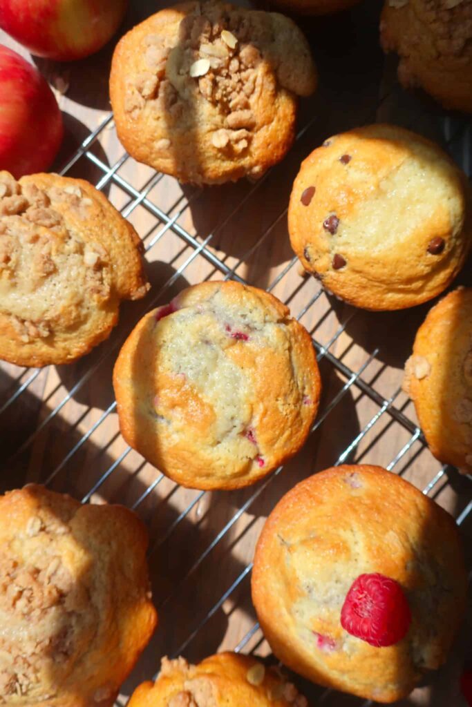 raspberry white chocolate muffins and other flavors on wire rack